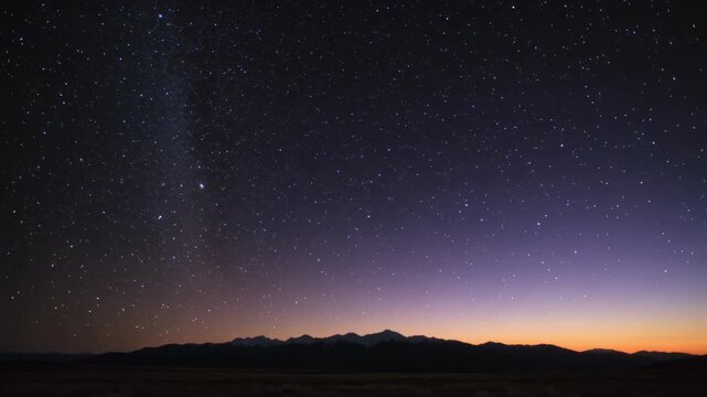 Showing Milky Way shifting across stars over mountains, horizon brightening, indicating sunrise