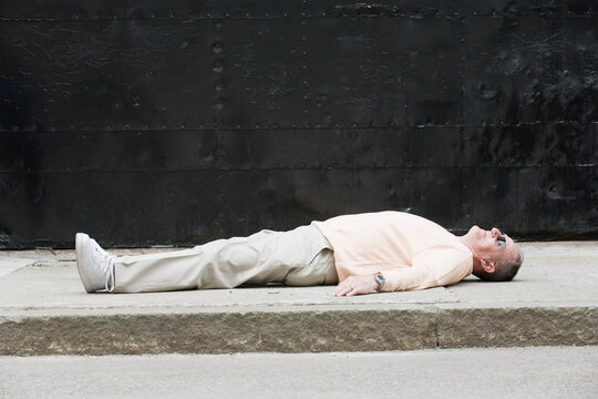 Senior man lying on a road