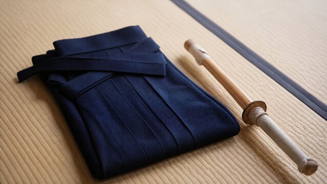 hakama. A neatly folded deep blue hakama and bamboo sword on tatami mat flooring. event programs, museum guides, designed for cultural heritage projects and event programs, supports education.