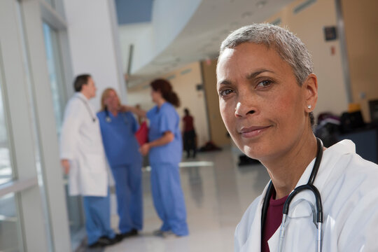 Portrait of a female doctor with her colleagues in the background