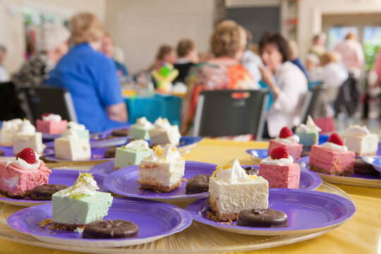 Dessert dishes at a lady's luncheon with senior women in the background
