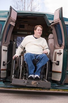 Man with spinal cord injury in a wheelchair coming out from a wheelchair accessible van