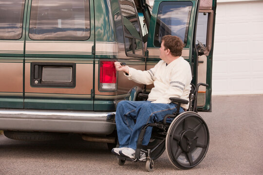Man with spinal cord injury using magnetized remote to close his accessible vehicle