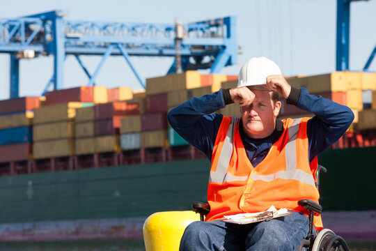 Transportation engineer in a wheelchair recording data for shipping containers and experiencing hot
