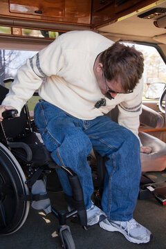 Man with spinal cord injury getting into the driver's seat from his wheelchair in accessible van