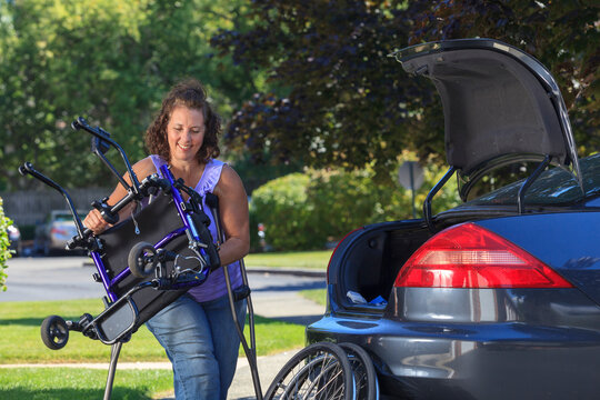 Woman with Spina Bifida taking apart wheelchair to put it in the back of car