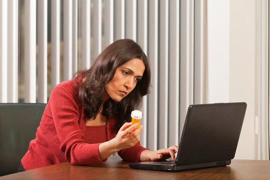 Businesswoman looking up medicine on computer
