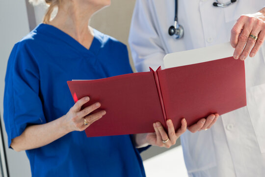 Doctor looking at files hold by a nurse