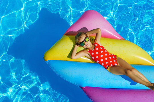 Child in swimming pool. Having fun on vacation at the hotel pool. Colorful vacation concept.