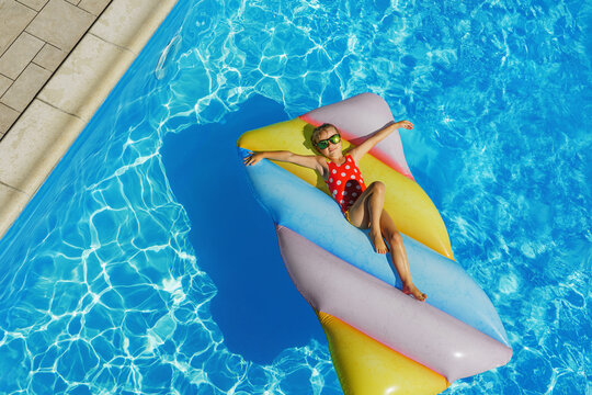Child in swimming pool. Having fun on vacation at the hotel pool. Colorful vacation concept.