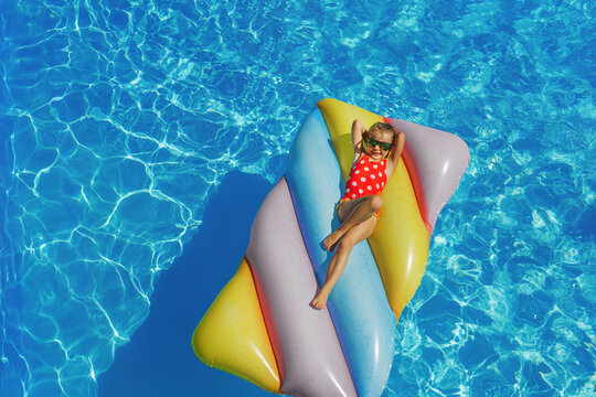 Child in swimming pool. Having fun on vacation at the hotel pool. Colorful vacation concept.