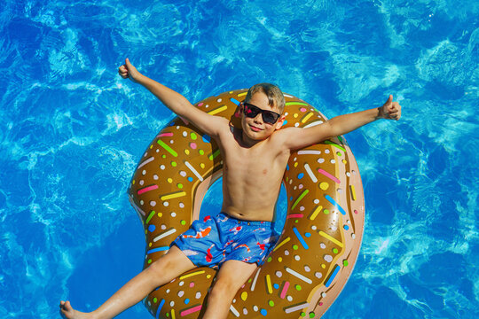 Child in swimming pool. Having fun on vacation at the hotel pool. Colorful vacation concept.