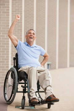 Man in wheelchair with spinal cord injury cheering