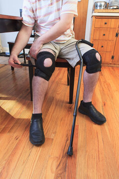 Man adjusting braces on his knees after anterior cruciate ligament (ACL) surgery