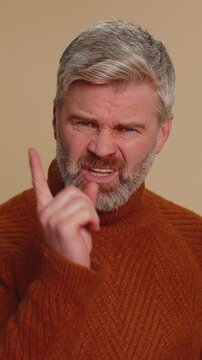 Quarrel. Displeased middle-aged man gesturing hands with irritation and displeasure, blaming scolding for failure, asking why this happened. Senior mature guy isolated alone on beige studio background