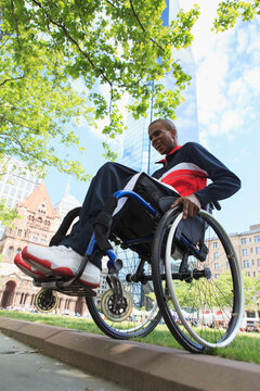 Man in wheelchair who had Spinal Meningitis going over a curb