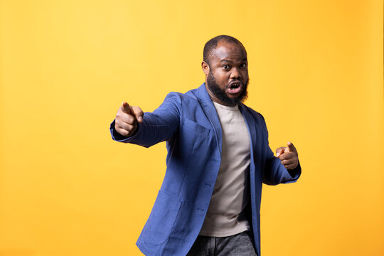 Portrait of African American motivational speaker holding monologue and gesturing with hands, isolated over studio background.