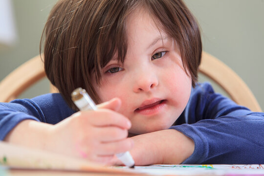 Child with Down Syndrome using coloring markers