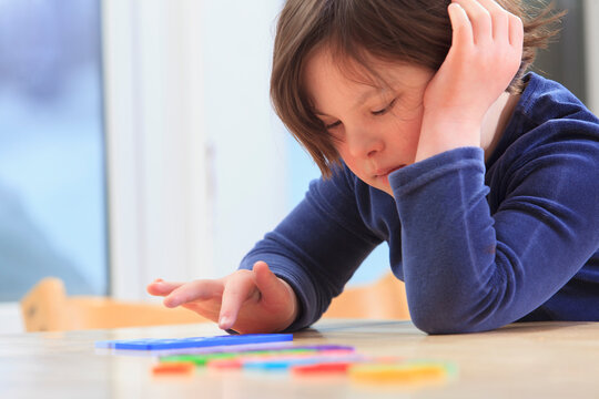 Little girl with Down Syndrome playing a learning game