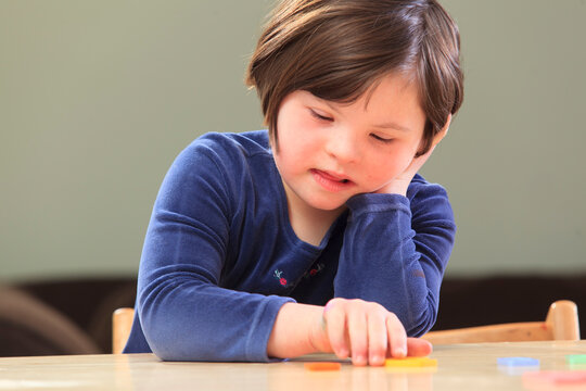 Little girl with Down Syndrome playing a learning game