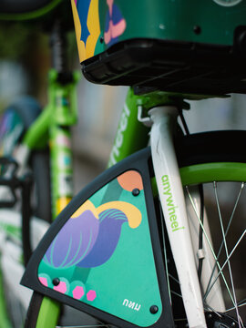 Close-up detail of Anywheel Bangkok BMA shared bicycle rear wheel guard with colorful illustrated graphic design artwork and saddle seat post
