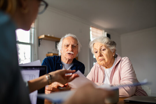 Senior couple reviewing finances with advisor at home