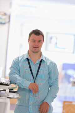Young man with Down Syndrome working as a hospital aid at the copy machine