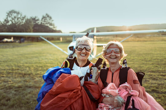 Two senior women skydivers smiling at airfield