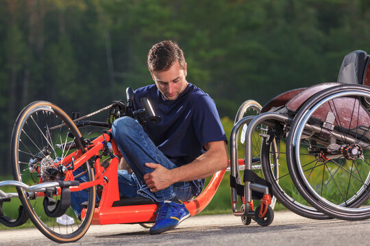 Man with spinal cord injury in his custom adaptive hand cycle getting into his wheelchair