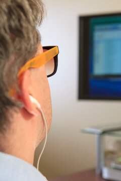 Man with congenital blindness using assistive technology at his computer to listen