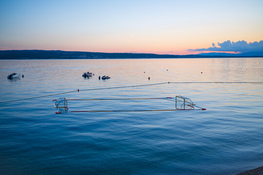 Floating water polo goals anchored in calm Adriatic waters at sunset