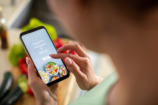 Person using healthy recipes app in kitchen