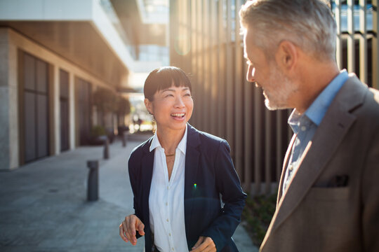 Business colleagues talking outside modern office