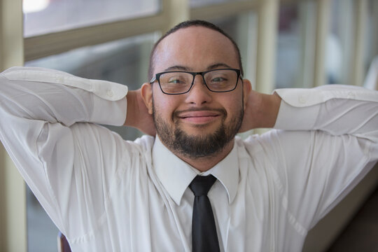 Portrait of happy African American man with Down Syndrome as a waiter in restaurant