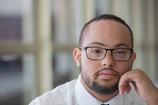 Portrait of African American man with Down Syndrome as a waiter in restaurant