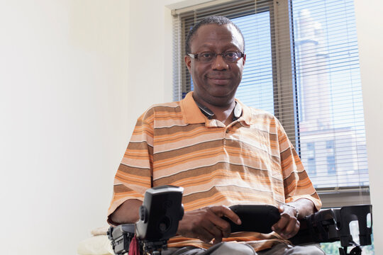 Man with Guillain-Barre Syndrome using his Bluetooth mini keyboard in his power chair at home