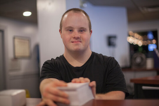 Portrait of waiter with Down Syndrome working in a restaurant