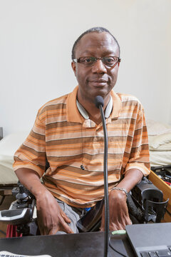 Man with Guillain-Barre Syndrome using his technical equipment at home office