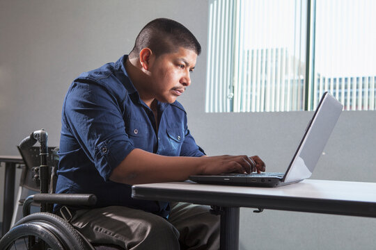 Hispanic man with Spinal Cord Injury working in an office