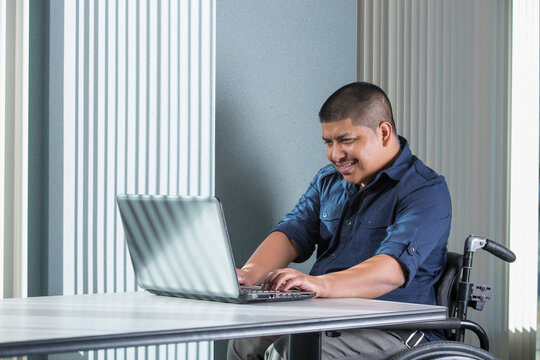 Hispanic man with Spinal Cord Injury working in an office