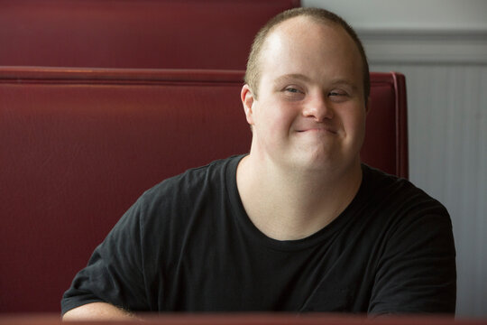 Portrait of happy waiter with Down Syndrome in a restaurant