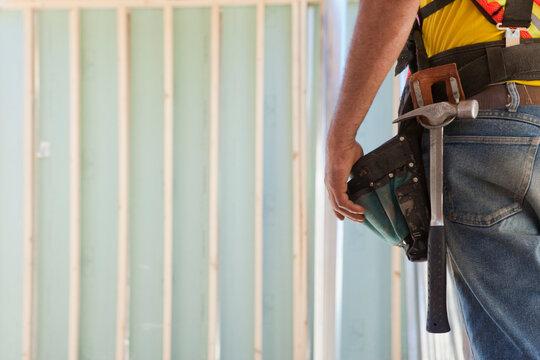 Mid section view of a carpenter wearing a tool belt