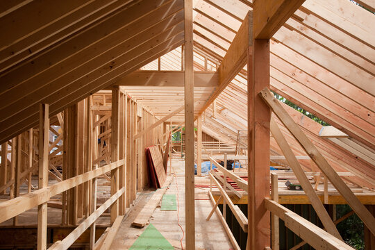 Upper floor room framing and rafters of a house under construction