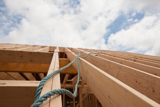 Safety ropes hanging from roof trusses at a house under construction