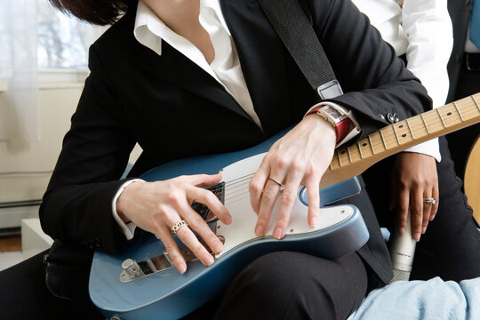 Midsection of a woman holding guitar