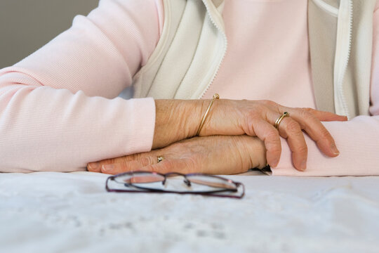 Midsection of a woman with glasses on a table
