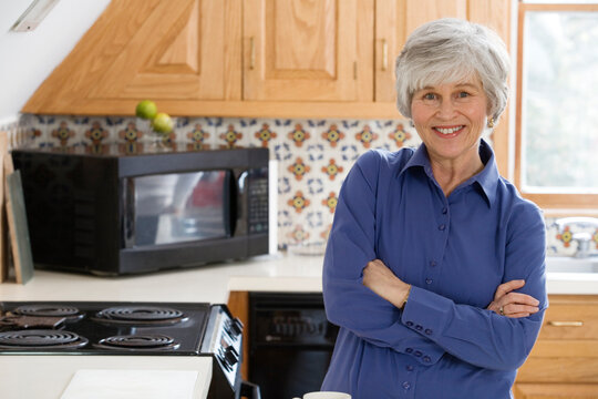 Portrait of a cheerful woman standing in a kitchen