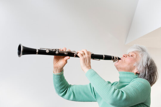 Side view of a mature woman playing a clarinet
