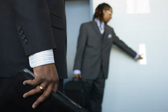 A young business man pressing push button of an elevator