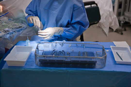 Assistant to the surgeon prepares for a surgery in an operating room
